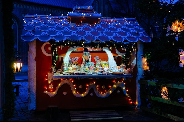 Riga, Lettonie - 28 décembre 2017 : Senior woman vendant l'une des friandises sucrées les plus traditionnelles qui sont des pains d'épice en photo au Marché de Noël à Riga, Lettonie.