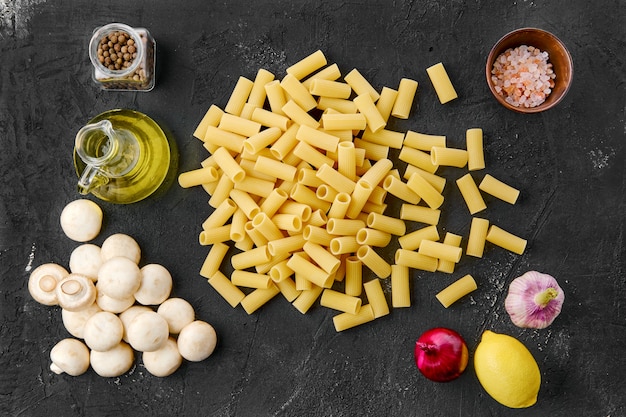 Rigatoni cru avec des ingrédients sur une table