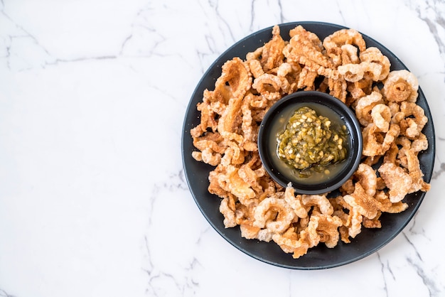 Rince de porc frit ou Snack au porc avec trempette au piment vert du nord de la Thaïlande