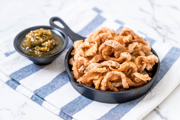 Rince de porc frit ou Snack au porc avec trempette au piment vert du nord de la Thaïlande