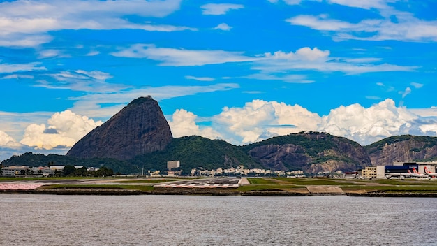 Photo rio de janeiro brésil - circa 2021 photo de la montagne du pain de sucre pao de acucar avec la piste de l'aéroport de santos dumont et la baie de guanabara pendant la journée