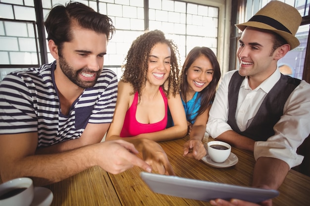 Rire des amis pointant et regardant la tablette tactile