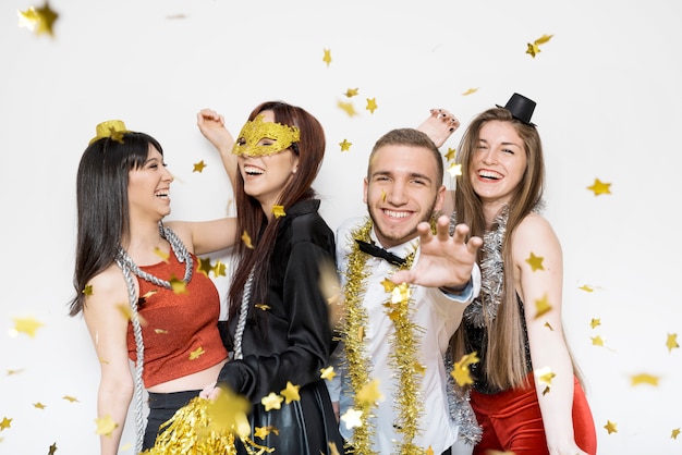 Photo rire dames et gars en tenue de soirée entre confettis d'ornement