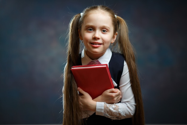 Rire écolière cheveux longs tenir crier livre rouge