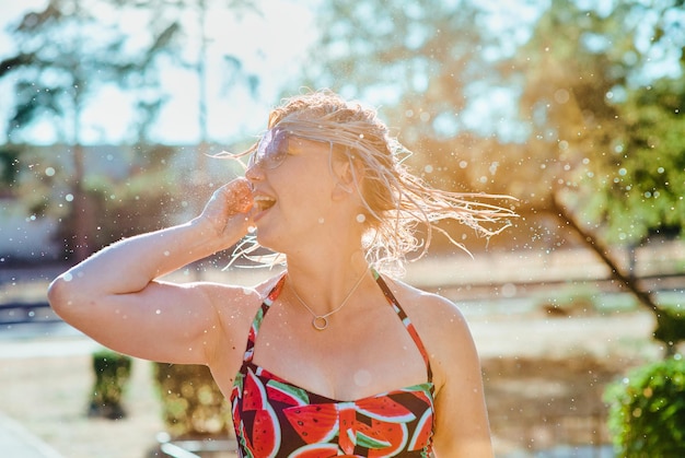 rire femme blonde émotionnelle avec les cheveux mouillés faisant des éclaboussures d'eau. Vacances, bonheur, amusement