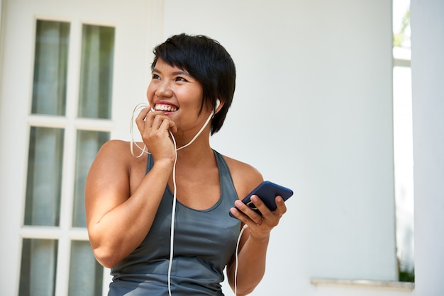 Rire femme sportive avec smartphone