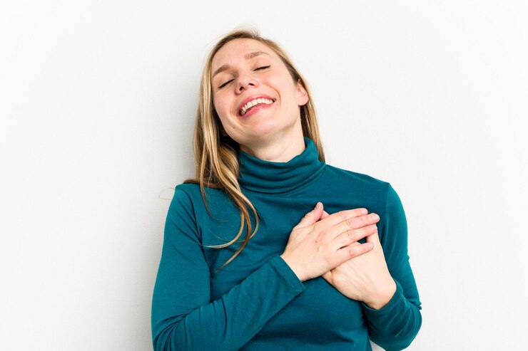 Photo rire en gardant les mains sur le coeur concept de bonheur