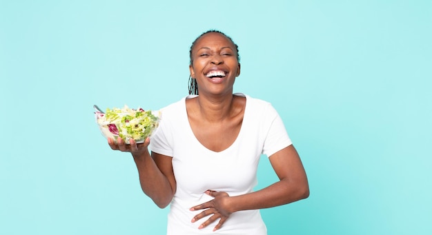 Rire à haute voix à une blague hilarante et tenir une salade