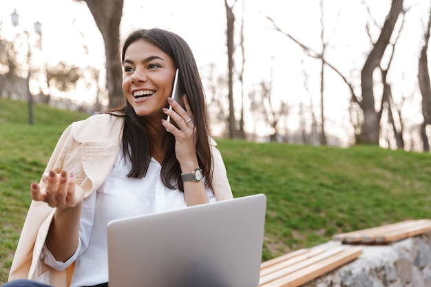 Rire jeune femme parlant au téléphone mobile