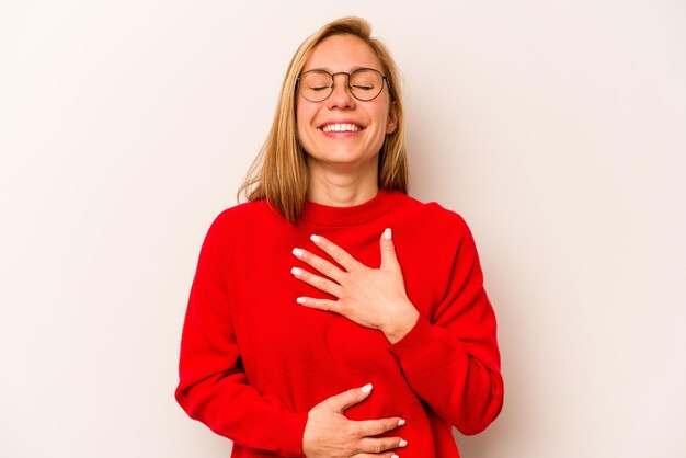 Rire joyeusement et s'amuser en gardant les mains sur le ventre