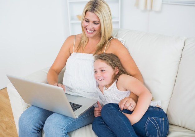 Rire mère et fille en utilisant un ordinateur portable