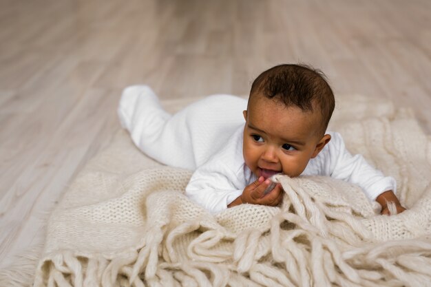 Rire Mixed Race Baby Boy Allongé sur le ventre à la maison