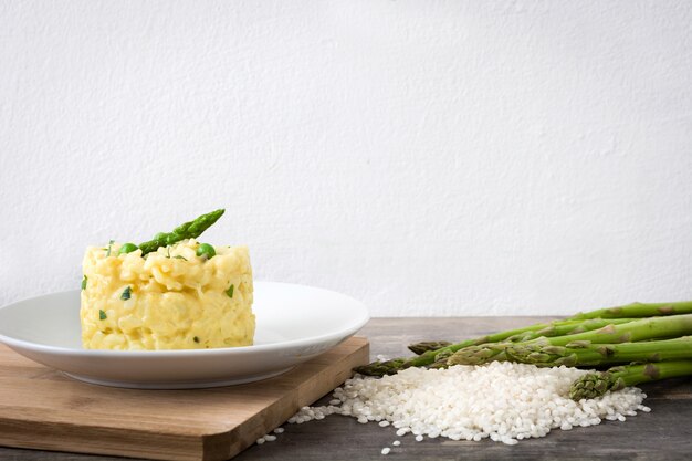 Risotto aux asperges, persil et petits pois sur une table en bois rustique copy space