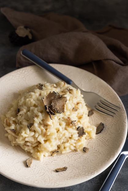 Risotto aux cèpes et truffes noires servi dans une assiette vue de dessus cousine gourmande