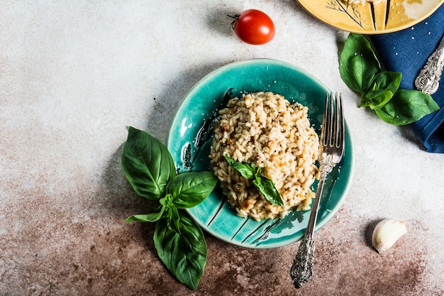 Risotto aux tomates sur une plaque verte au basilic. Nourriture italienne. Concept de nourriture végétalienne. Cuisine italienne. Plat de tomate. Nourriture saine. Plat d'été. Nourriture maison.