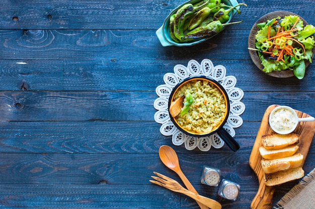 Risotto végétarien avec divers légumes, sur une table rustique en bois,