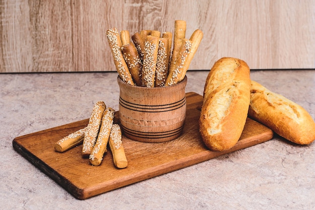 Ð¡rissez du pain avec des petits pains. Baguettes françaises. Pain croustillant frais. Fond de pain. Race différente sur fond en bois.