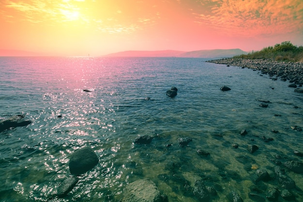 Rivage rocheux de la mer de Galilée au lever du soleil