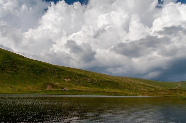 Rive du lac alpin en été avec de beaux cumulus