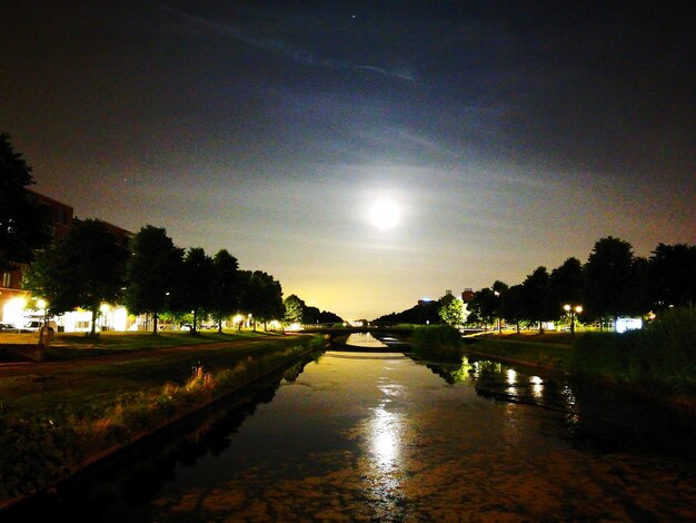 Photo la rivière au milieu des arbres illuminés contre le ciel au coucher du soleil