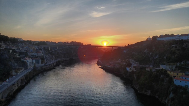 La rivière au milieu des bâtiments contre le ciel au coucher du soleil