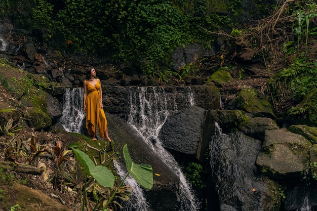 Rivière de montagne. Ravi de femme écoutant les sons de l'eau en marchant dans la forêt