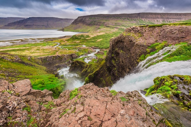 Rivière de montagne se jetant dans le lac entre les montagnes Islande