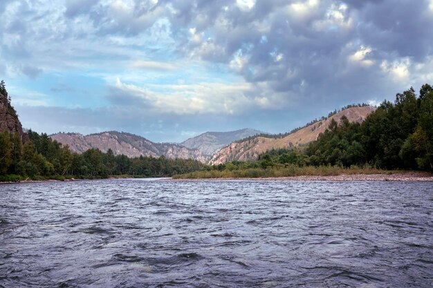 Une rivière et des montagnes boisées le long de ses rives. Paysage d'été, beauté de la nature.