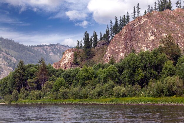 Une rivière et des montagnes boisées le long de ses rives. Paysage d'été. Voyage, randonnée, mode de vie sain.