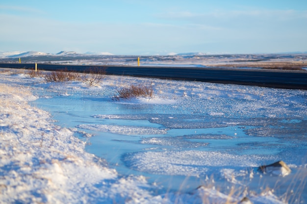 Rivière sur la plaine d'Islande. Les berges sont couvertes de neige. Paysage d'hiver, grands espaces.