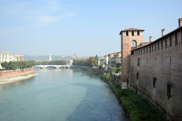 Une rivière près d'un ancien mur de forteresse avec une tour et un pont au loin