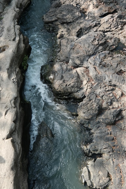 Une rivière avec des rochers et de l'eau au premier plan et le mot mer au fond de la roche volcanique gelée