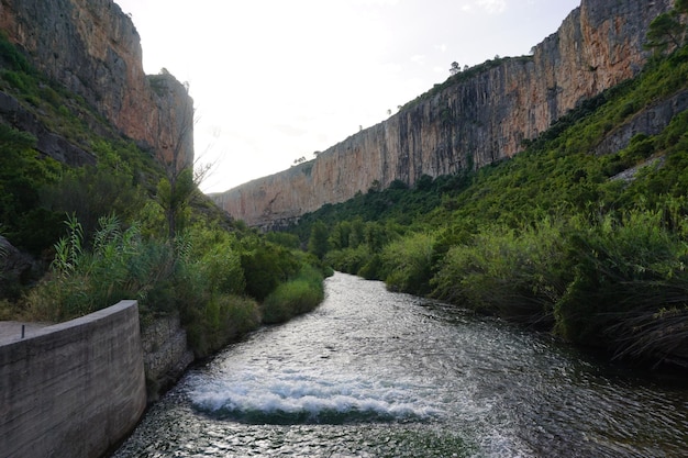 Une rivière traverse un canyon avec une falaise en arrière-plan.