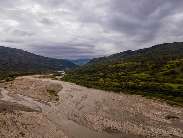 Une rivière traverse une vallée avec des montagnes en arrière-plan.