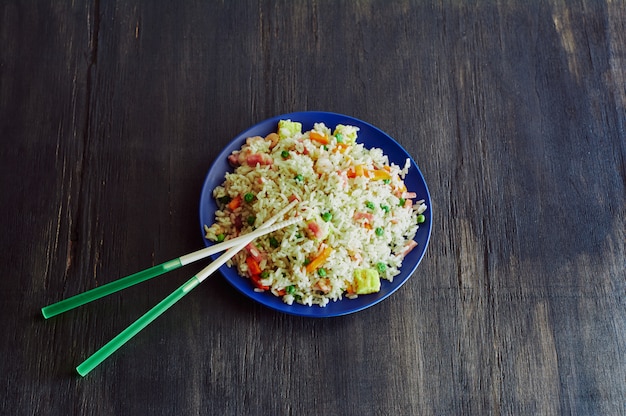 Riz 3 délices dans un plat en fibre de bambou avec bâtons de résine