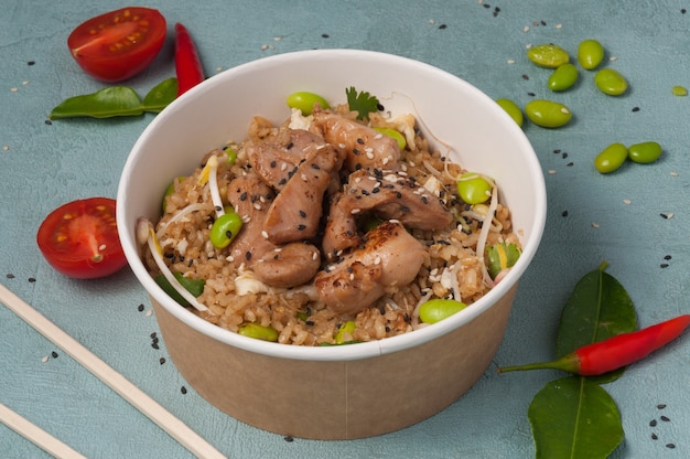 Riz à l'ail avec du poulet et des haricots dans un bol artisanal. concept : livraison de nourriture