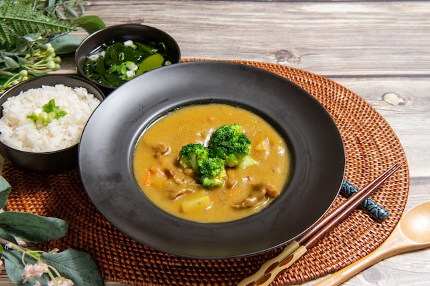 Riz au curry de porc sur fond de bois (décoration de table)