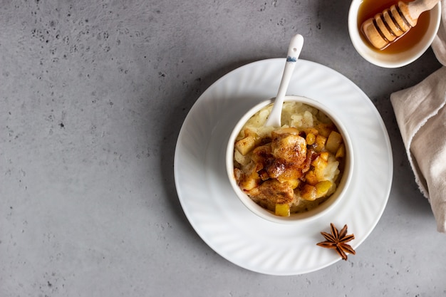 Riz au lait avec des fruits, du miel et des épices. Petit déjeuner ou dessert sain.