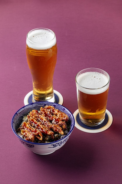 Riz au poulet Katsudon avec de la bière sur fond violet