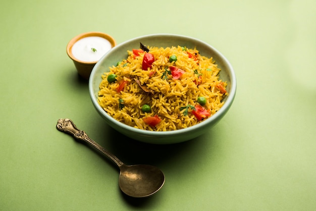 Photo riz aux tomates également connu sous le nom de tamatar pilaf ou pulav à base de riz basmati, servi dans un bol. mise au point sélective
