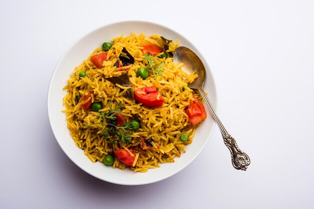 Riz aux tomates également connu sous le nom de Tamatar Pilaf ou pulav à base de riz basmati, servi dans un bol. mise au point sélective