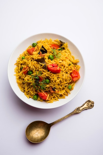 Riz aux tomates également connu sous le nom de Tamatar Pilaf ou pulav à base de riz basmati, servi dans un bol. mise au point sélective