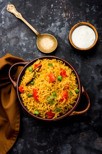 Photo riz aux tomates également connu sous le nom de tamatar pilaf ou pulav à base de riz basmati, servi dans un bol. mise au point sélective