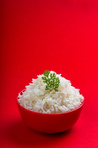 Photo riz basmati blanc cuit dans un bol rouge sur rouge