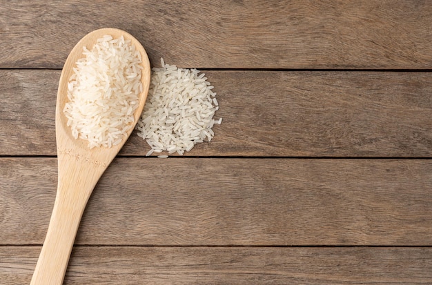 Riz blanc cru dans une cuillère sur une table en bois avec espace de copie