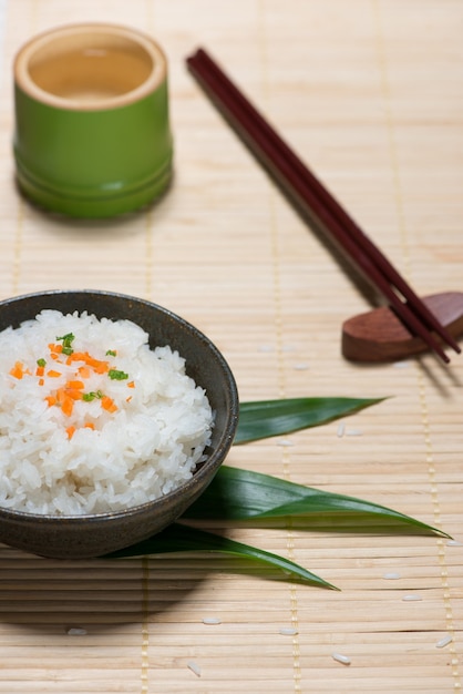 Riz bouilli dans un bol sur une table en bois.