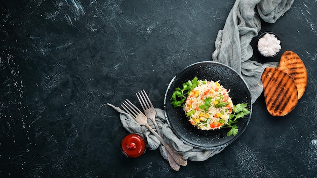 Riz bouilli et légumes Risotto Dans une assiette noire Vue de dessus Espace de copie gratuit