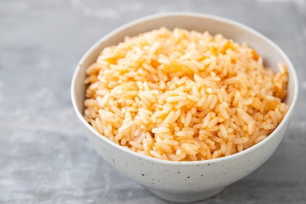 Riz bouilli à la tomate dans un bol sur table en céramique