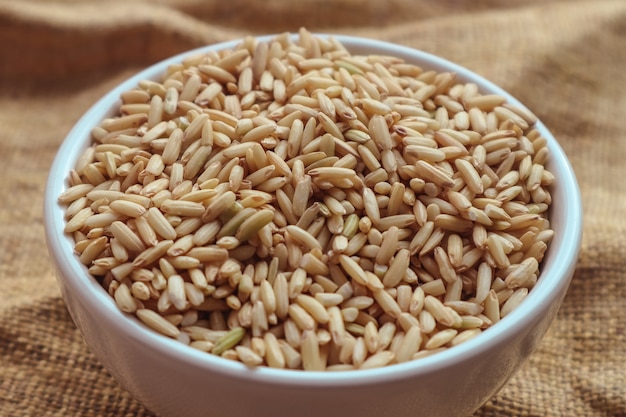 Riz brun cru dans un bol. fond de nourriture vue de dessus