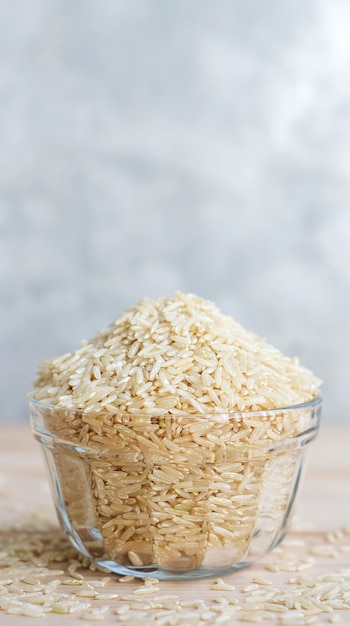 Riz brun dans un bol sur un fond en bois et gris